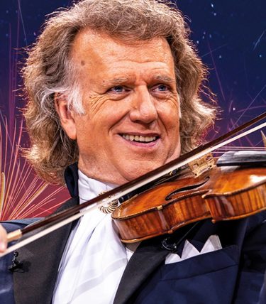 André Rieu performs on stage with fireworks in the background