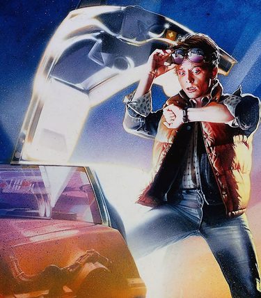 A young man stepping out of a futuristic looking car. He is looking at his watch.