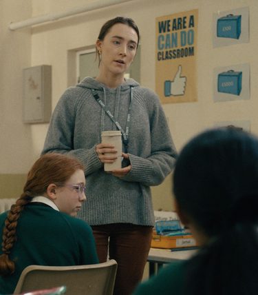 Saorise Ronan stars as a teacher. She is standing in a class of children.