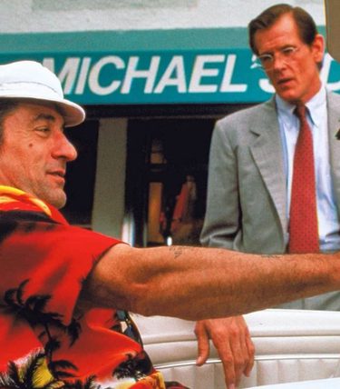 Robert De Niro is sat in a car talking to Nick Nolte next to the car.