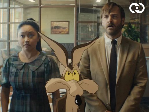 Wile E Coyote is standing in front of a man and woman in an office.
