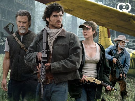 Cast includign jacob Elordi are standing in knee-high grass infront of a bi-plane.