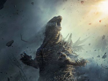 Godzilla is rearing up in a smoke filled sky roaring at the heavens.