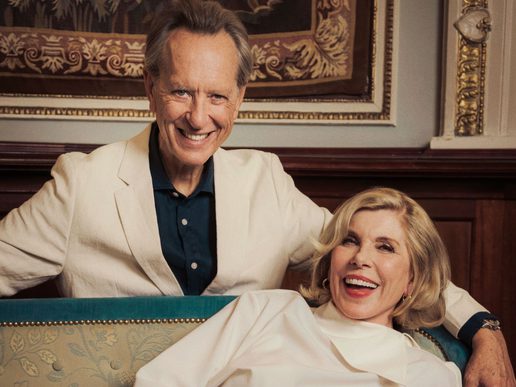 Richard E Grant and Christine Baranski are dressed elegantly in a posh house.