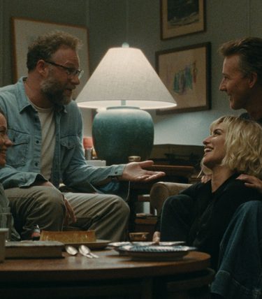 Two couples are sat at a table chatting and look friendly.