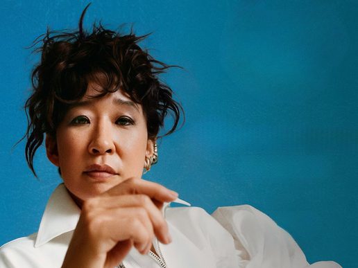 A close-up picture of Sandra Oh on a blue background.