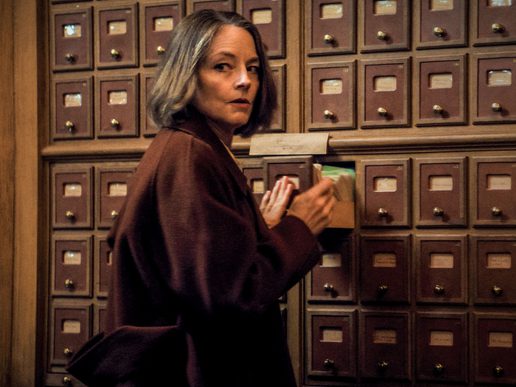 Jodie Foster is is looking in a record file, but looking around suspiciously.
