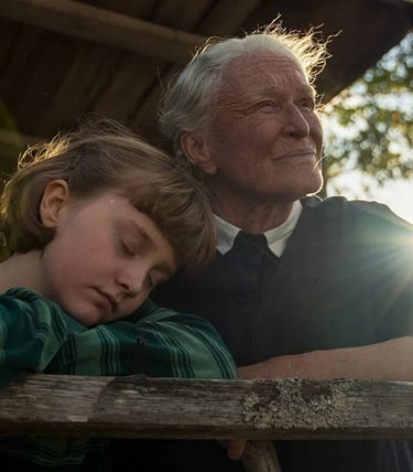 An older woman and a young girl are looking into the sunset.