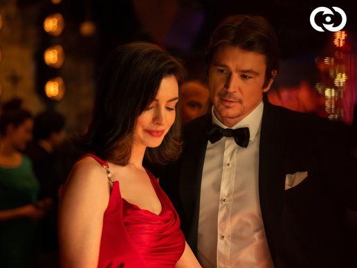 A man and woman are standing at a party, they are dressed very nicely.