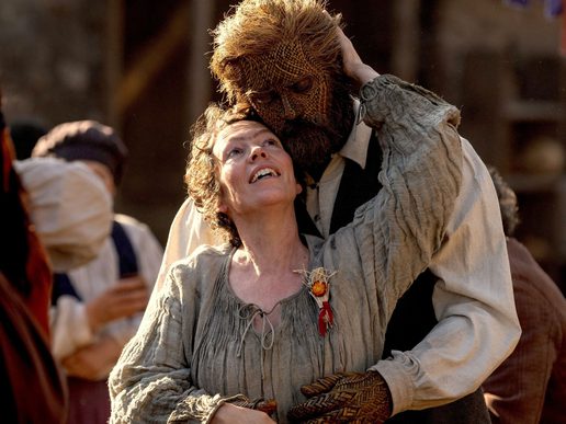 A woman is dancing with a man who is made of wicker.