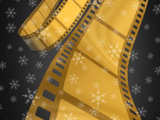 A festive illustration of two curling gold film strips set against a dark background, with white snowflakes scattered across the image. The design combines cinema imagery with a Christmas theme using gold, black and white colours.