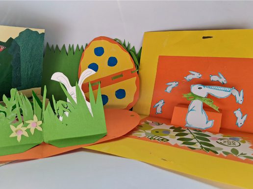 Colourful handmade pop-up cards featuring Easter designs, including rabbits, a decorated egg, grass and spring flowers.