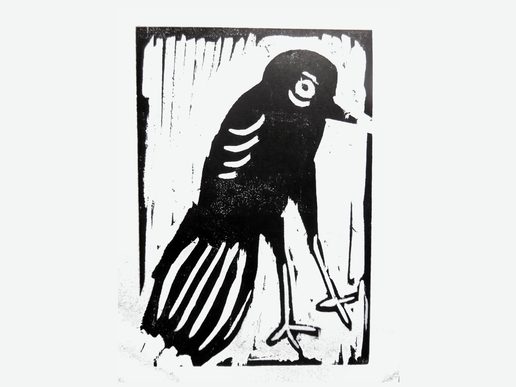 Black-and-white linocut print of a bird standing in profile, rendered with bold, simplified shapes and strong contrast. White carved lines define the bird's eye, wing and tail feathers against a solid black silhouette, creating a striking, graphic composition.